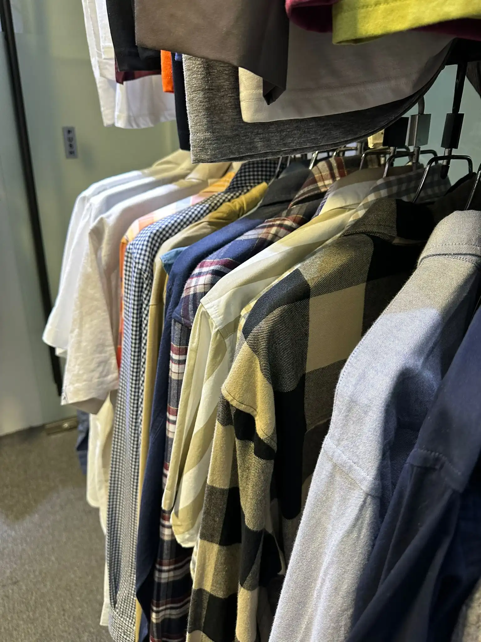 Close-up of shirts and jackets on the showroom rail